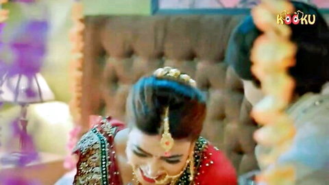 Indian bride in red lehenga with jewelry smiling in Sajani Kooku series