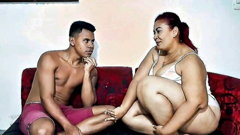 Curvy big ass Latina MILF in lingerie flirts with shirtless muscular young hunk on couch