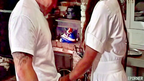 Sexy ebony nurse in white dress with tattooed man, intimate kitchen tease