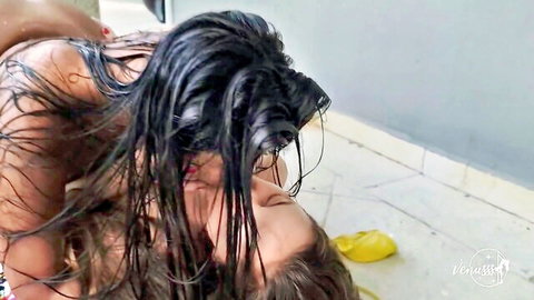 Two wet brunettes passionately embracing naked by the pool
