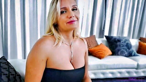 Blonde MILF in strapless black dress teasing cleavage seductively