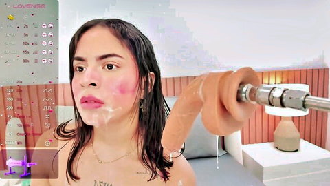 Brunette webcam slut with thick cum dripping on pink lips beside huge tan wall-mounted dildo