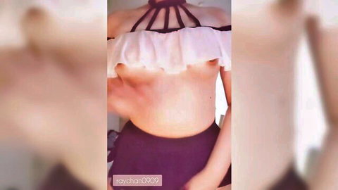 Blurry solo Asian woman in frilly harness top exposing breasts, hands teasing nipples