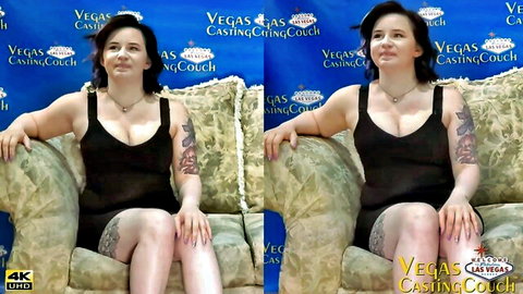 Ryder Die in black dress, tattoos visible, sitting seductively on casting couch