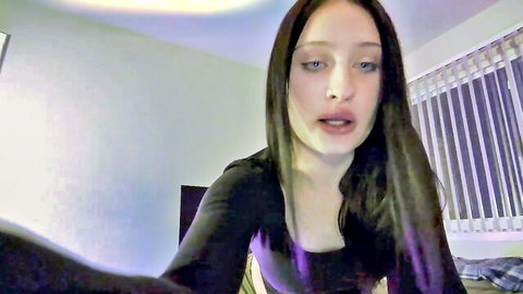 Young seductive brunette webcam girl in tight black top showing deep cleavage