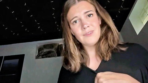 Maggierosexo in nurturing mommy pose, smiling in black V-neck top