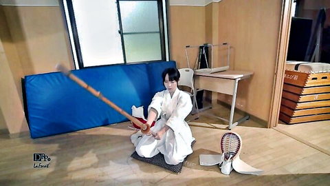 Seductive Japanese girl in kimono kneeling with kendo stick