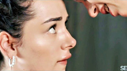 Brunette beauty gazes passionately with parted lips as man leans in nose-to-nose intimately