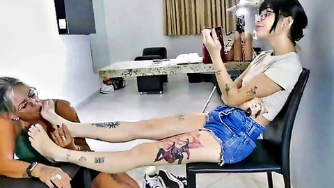 Mature lesbian worships young tattooed girl's sneaker and socked foot in domination fetish