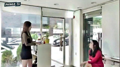 Two sexy Asian women in revealing office outfits, one standing in black sheer top and mini skirt