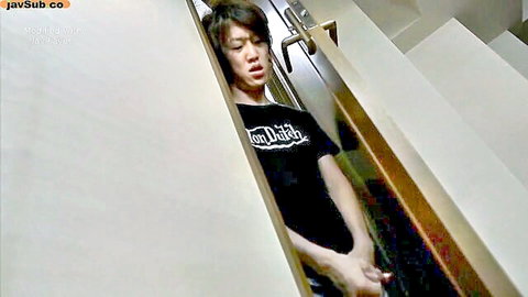 Japanese brunette peeking playfully from under stairs in tight black t-shirt