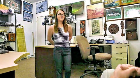 Brunette woman in glasses wearing striped tank top and jeans, standing confidently