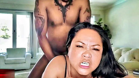 Muscular black man dominating Asian woman in lingerie from behind