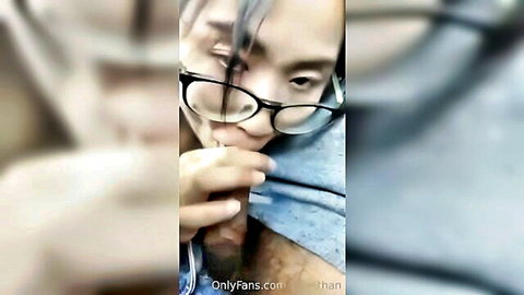 Asian babe with glasses eagerly sucks thick cock in closeup blowjob.