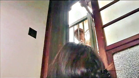 Japanese woman intimately close to man's face through prison bars in teasing encounter