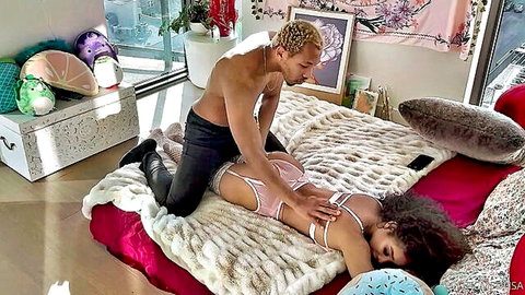 Curvy ebony woman in pink lingerie receives sensual massage from muscular man