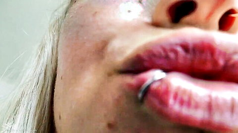 Close-up of blonde woman's plump lips with silver lip ring in giantess Aurora fetish video