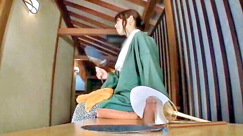 Miho Tsuno in green kimono holding fan with dildo nearby