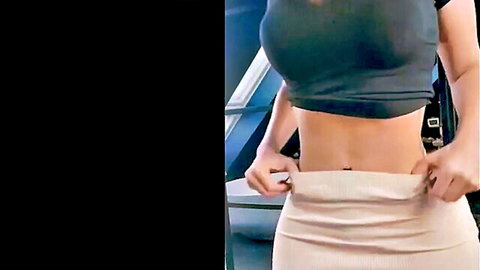 Amirah posing in black crop top and beige skirt, flaunting toned midriff