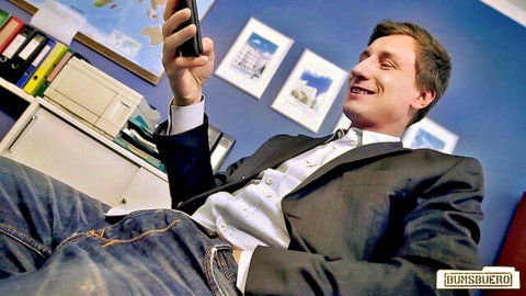 Man in suit smiling at phone in office, July Johnson MILF tease