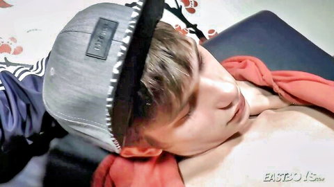 Shirtless young teen in cap lying relaxed for feet play handjob