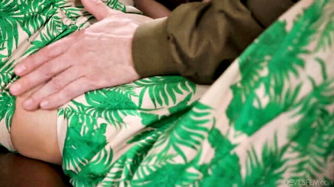 Adira Allure in green leafy dress with hands caressing her abdomen