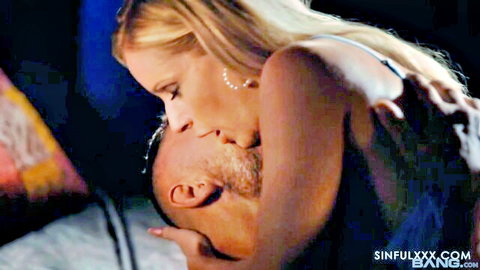 Danielle Renae blonde MILF passionately kissing muscular man in bed