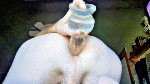Hand shoving clear glass dildo deep into hairy white man's tight asshole in solo anal play