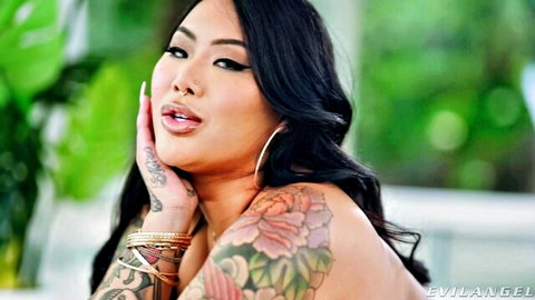 Seductive tattooed Asian woman with long black hair and floral ink
