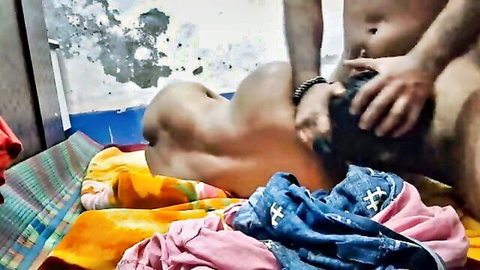 Muscular naked man grabs another's head and crotch in rough gay domination on colorful bed