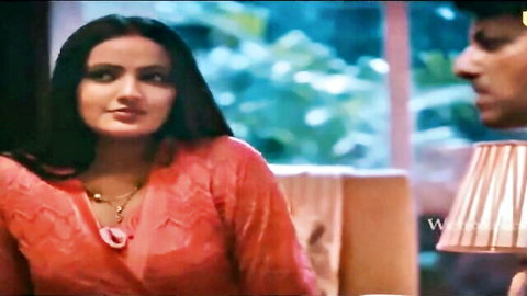 Seductive Indian woman in shiny orange dress showing cleavage with man, Ullu series