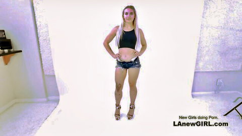 Blonde newbie stands in crop top and denim shorts for lesbian strap-on debut