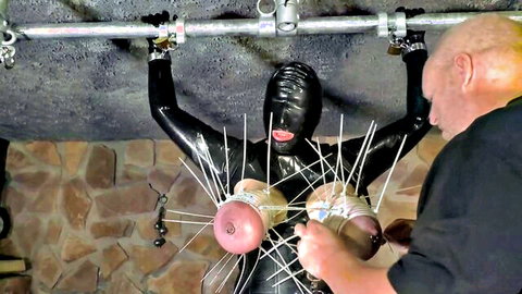Latex bondage slave with spiked tits endures nipple clamps torture from bald dom