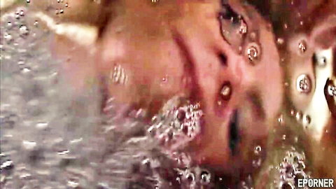 Blonde woman underwater with open mouth and bubbles, deep throat tease