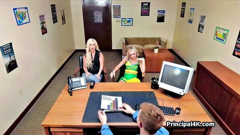 Blonde cheerleader in green dress and casual soccer mom with man at desk in office