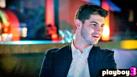 Handsome suited man smiling seductively at neon-lit bar counter