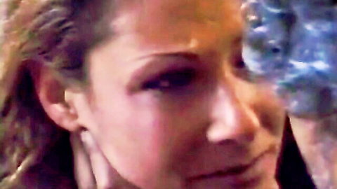 Close-up of aroused brunette woman's intense gaze and parted lips in domination scene