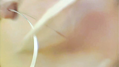Blurry closeup of fair-skinned woman's cheek with silver hoop earring