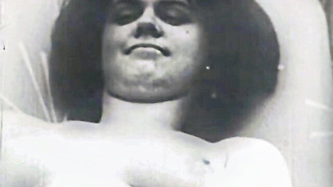 Vintage brunette man smiling shirtless with long wavy hair and lace veil exposing bare chest
