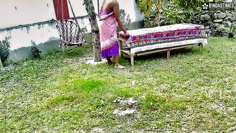Indian village girl in pink saree standing barefoot outdoors, teasing vibe