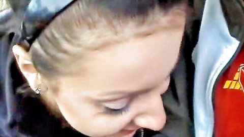Blonde woman in shiny black headband closeup profile next to man in red sports jacket in car