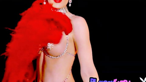 Glamorous blonde burlesque babe teases big tits with red feathers and sparkling chain pasties