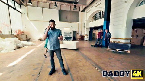 Older man on phone ignores skinny young brunette in short green dress in warehouse Daddy4K tease
