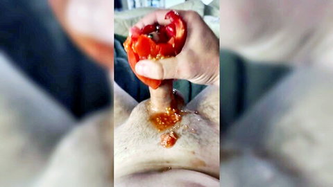 Hand stroking penis with red tomato, food play close-up