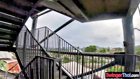 Outdoor metal stairs and cloudy Thai landscape with swingerthai.com watermarks