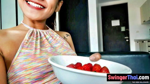 Sexy Thai teen girlfriend in colorful halter top teases with juicy strawberries smiling POV selfie
