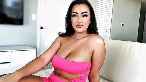 Thick brunette with massive bouncy tits in skimpy pink cutout bodysuit teasing on couch