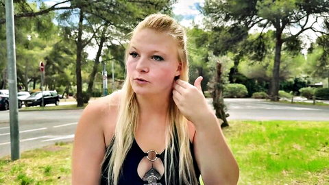 Blonde babe in sexy black ring top teases with pouty lips and hand gesture outdoors