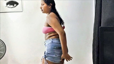 Curvy Latina babe teases juicy ass cheeks in tight denim shorts and pink bralette side view