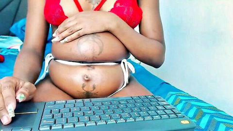 Ebony pregnant woman in red lace bra and white bikini, tattooed belly exposed